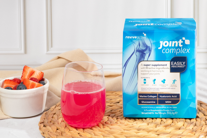 Understanding Joint Health with a box of Joint Complex in the kitchen with the drink and fruit